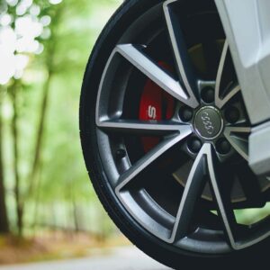 Close up of a wheel on an Audi vehicle stopped on a road in a forested area